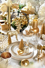 Christmas table setting with decors in white and gold colors