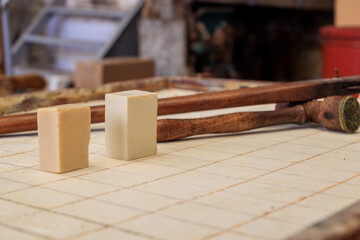 Cut olive oil soap bars ready to be stamped with the soap stamp in a soap factory, Greece, Corfu,...