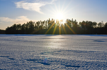 Sunny landscape at frozen lake