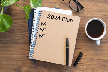Note book with 2024 goals text on it to apply new year resolutions and plan.	 - obrazy, fototapety, plakaty