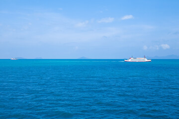 A cargo ferry sails across the blue sea on the Gulf of Thailand