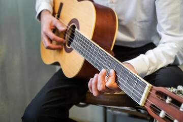 close-up of classical guitarist holding Spanish guitar close up in studio