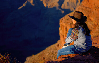 Young woman enjoying the incredibly impressive view over the majestic Grand Canyon - travel...