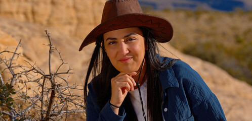 Portrait shot of a young cowgirl wearing a cowboy hat posing for the camera - travel photography