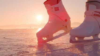 DOF, LENS FLARE, CLOSE UP: Unrecognizable lady hits ice with toe picks on skates - obrazy, fototapety, plakaty