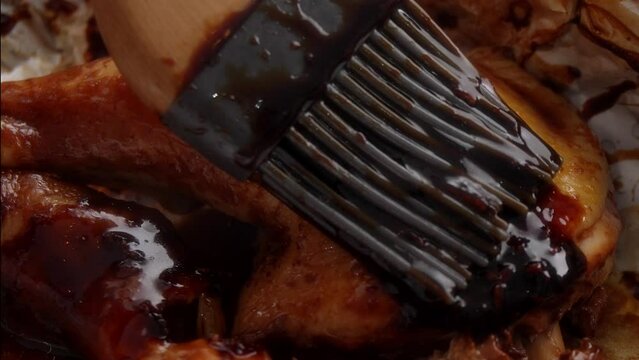 Glazing Hot Oven-Baked Chicken Thigh with Barbecue Sauce Close-up.