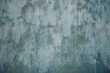 Old blue cracked paint. The texture of the paint with cracks. Dried in the sun and cracked color on the wall of country house. Peeling coating. The texture of the cracks. Grunge texture background.