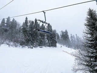 Ski Lift snowy mountain winter forest with chair lift At The Ski Resort in winter. Snowy weather...