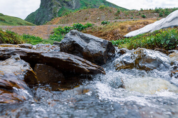 Raging water of a fast mountain river in a picturesque beautiful mountainous area, flowing water...