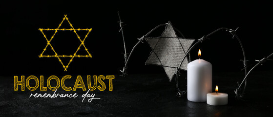 David star, barbed wire and burning candles on dark background. International Holocaust Remembrance...