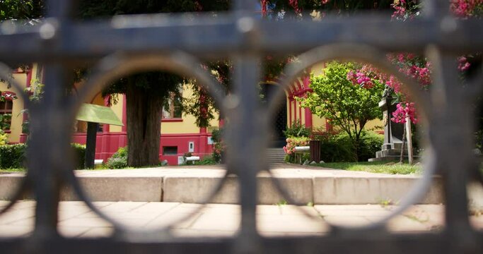 Shot through metal fence of entrance of high school with beautiful facade