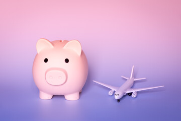 Saving money for a holiday concept. Piggy bank with a toy plane. Vacation budget planning. Savings...
