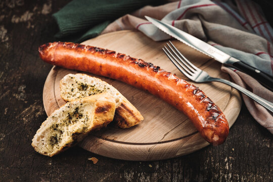 Gegrillte &ouml;sterreichische K&auml;sekrainer auf rustikalem Holzbrett