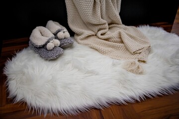 the blanket has two slippers on top of it on the floor