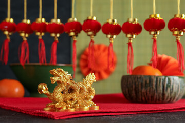 Festive composition with golden dragon figurine, traditional Chinese decor and mandarins on black...