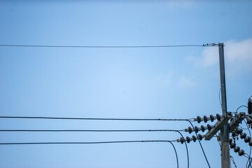 An electrical pole that shows the disorder in the arrangement of the cables.