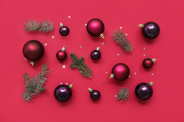 Composition with Christmas balls and fir branches with sparkles on red background