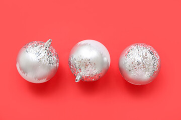 Composition with silver Christmas balls on red background