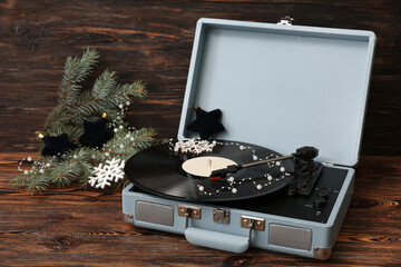 Vintage turntable with Christmas decorations on wooden background