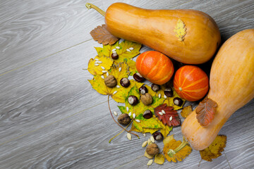Image of pumpkin and autumn leaves on a wooden surface providing space for products or...