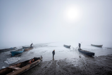 The story of a fisherman who wants to make a way for herself on a frozen lake on winter days and tries to get her fishing boat out of the ice.  - obrazy, fototapety, plakaty