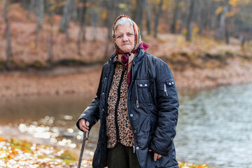 Old healthy grandmother portrait in the autumn forest with beautiful expression