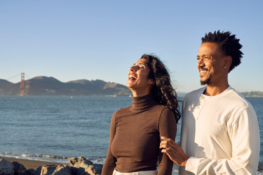 Interracial Couple at The Beach Together in Love Enjoying Each Other Company Smiling