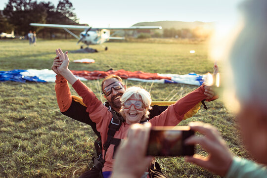 Two senior skydivers relishing the moment and taking a selfie after their jump