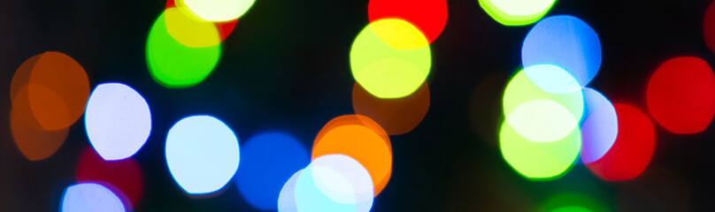 Banner. Colourful festive bokeh lights on background. Abstract multicolored light. Christmas or New...