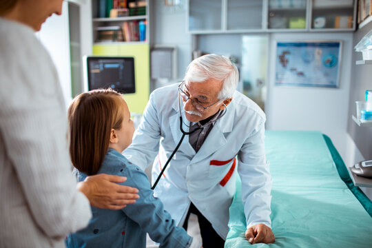 Senior Male Pediatrician Hold Stethoscope Exam Child Boy Patient Visit Doctor With Mother At Hospital