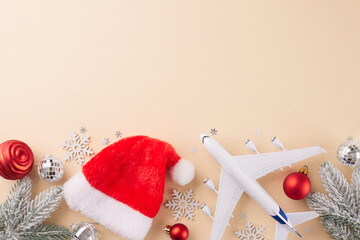 Holiday travel inspiration for Christmas. Top view photo of Santa hat, airplane model, xmas balls,...