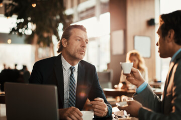 Two businessman sitting in cafe talking - obrazy, fototapety, plakaty
