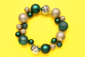 Frame made of Christmas tree balls on yellow background