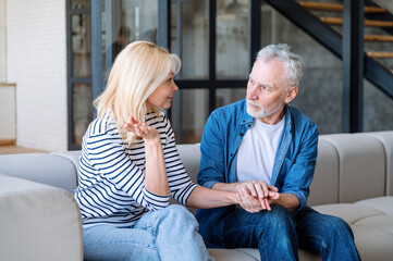 Elderly man listening carefully and try to understand woman