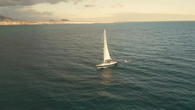 Aerial orbital clip of the sunrise with silhouetted boat yachts in open water off the island of Lobos near Corralejo in Fuerteventura Canary Islands Spain