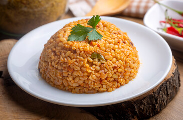 Traditional turkish bulgur pilaf with tomato sause in plate (Turkish name; meyhane pilavi)