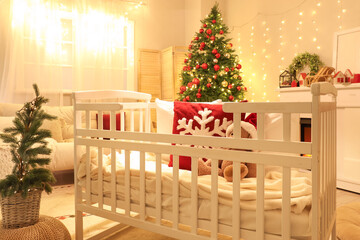 Interior of bedroom with baby crib, Christmas trees and glowing lights in evening - obrazy, fototapety, plakaty