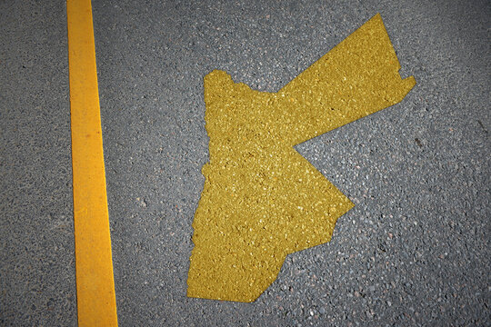 yellow map of jordan country on asphalt road near yellow line.