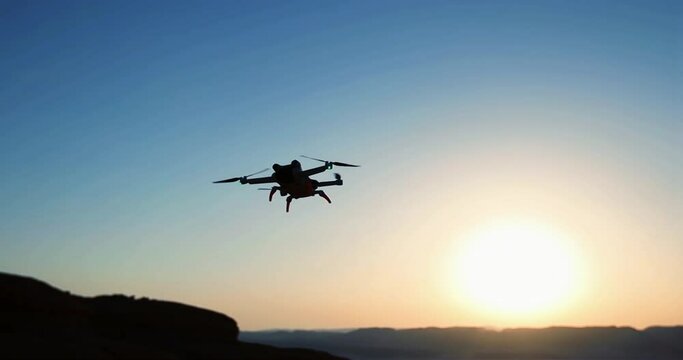 Drone flying against sunset sky