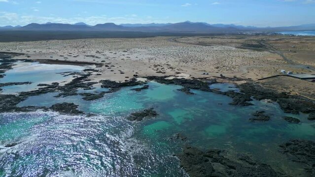 Aerial orbital clip of the natural pools and volcanic rock formations near El Cotillo in Fuerteventura Spain