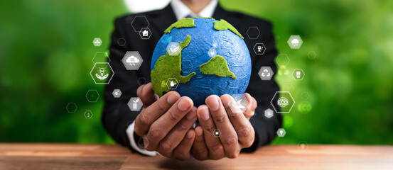 Businessman holding Earth with eco friendly icon design symbolize business company commitment to...