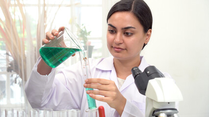 Researcher asian woman wear lab cost work mixing test tube specialist sample chemist equipment with microscope at laboratory. Student young girl examining biotechnology health medical. Health science.