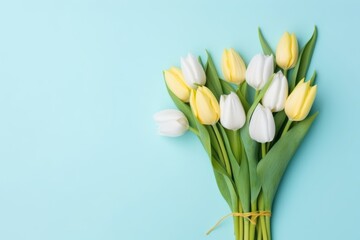 Beautiful composition spring flowers. Bouquet of yellow white tulips flowers pastel blue background. Valentine's Day, Easter, Birthday, Happy Women's Day, Mother's Day. Flat lay, top view, copy space