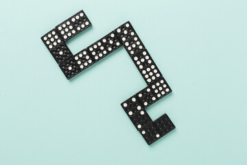 Black domino tiles on color background, top view