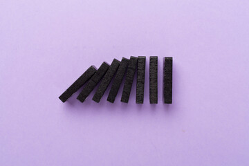 Black domino tiles on color background, top view