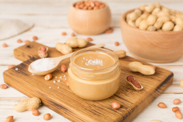 Obraz na płótnie Canvas Jar of peanut butter on wooden table