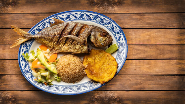 Fried horse mackerel served with patacon, coconut rice and vegetable salad - Food from the South Pacific