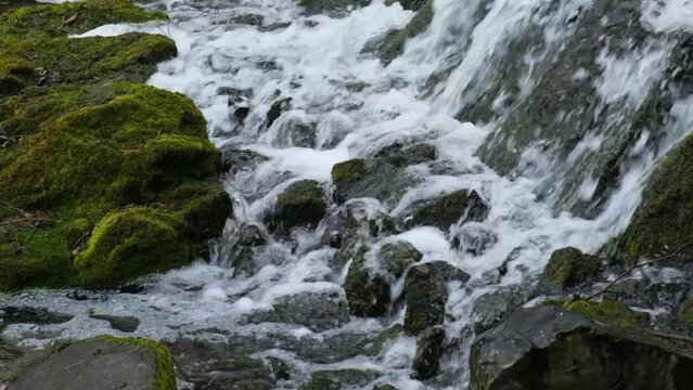 Slow motion footage of flowing waterfall close-up showing the movement of water. Mountain waterfall pours water onto the rocks Cascades of rivers and streams. Respect for the ecosystem and renewable