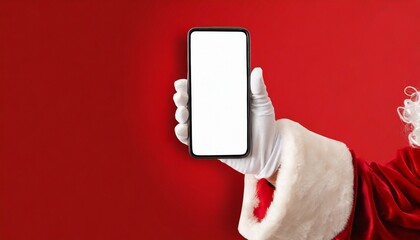 Hey, new cellphone. Santa holding modern phone with white blank screen over red background, panorama. Image of hand of santa claus holding smartphone with blank screen and copy space on background.