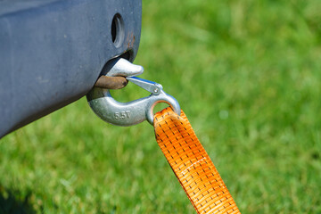 Tow hook with orange strap on car. Towing equipment.